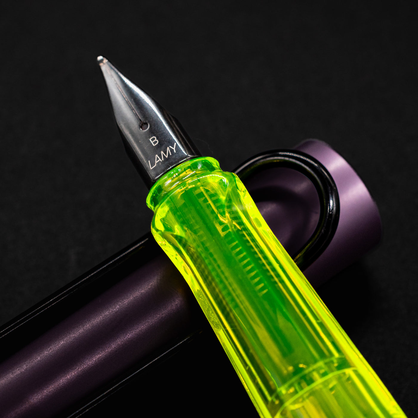 Macro shot of the stainless steel nib marked "B" on the LAMY Al-Star Aubergine Fountain Pen, with clear view of feed and grip.