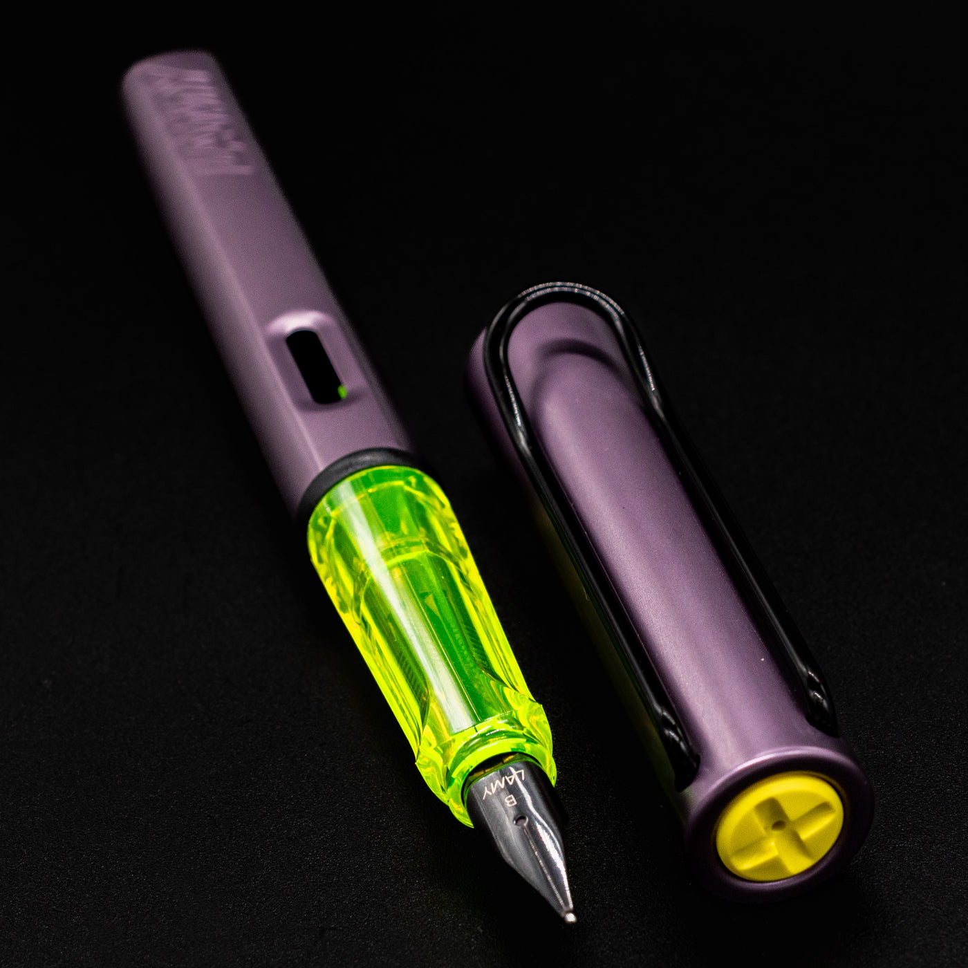 LAMY Al-Star Aubergine Fountain Pen uncapped, highlighting the translucent yellow grip and matte purple aluminum barrel.