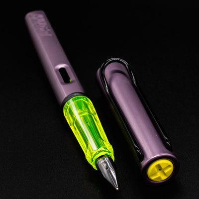 LAMY Al-Star Aubergine Fountain Pen uncapped, highlighting the translucent yellow grip and matte purple aluminum barrel.