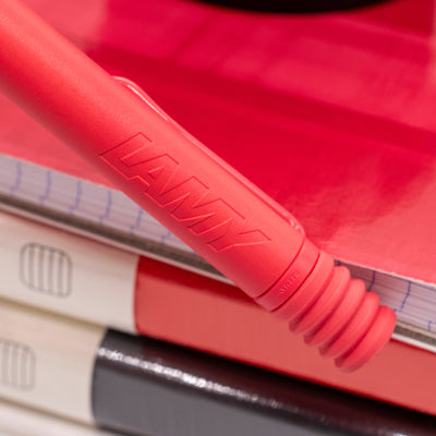 Close-up of LAMY logo on the matte pink body of the Sunset Coral ballpoint pen