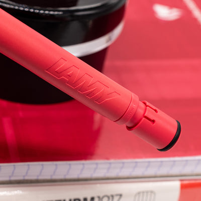 Close-up of the embossed LAMY logo on the Sunset Coral mechanical pencil barrel