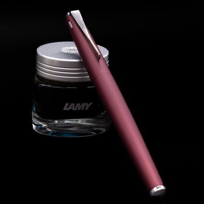LAMY Fountain Pen Aubergine propped on a bottle of ink