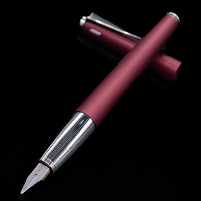 Maroon fountain pen with silver accents on a black background