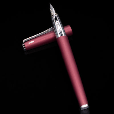 Maroon fountain pen with silver clip on a black background