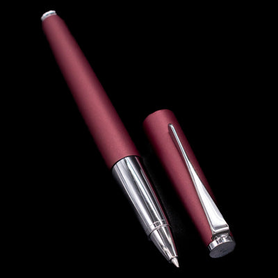 A full view of the LAMY Studio Rollerball Pen in Orion uncapped, with its cap laying next to the pen.