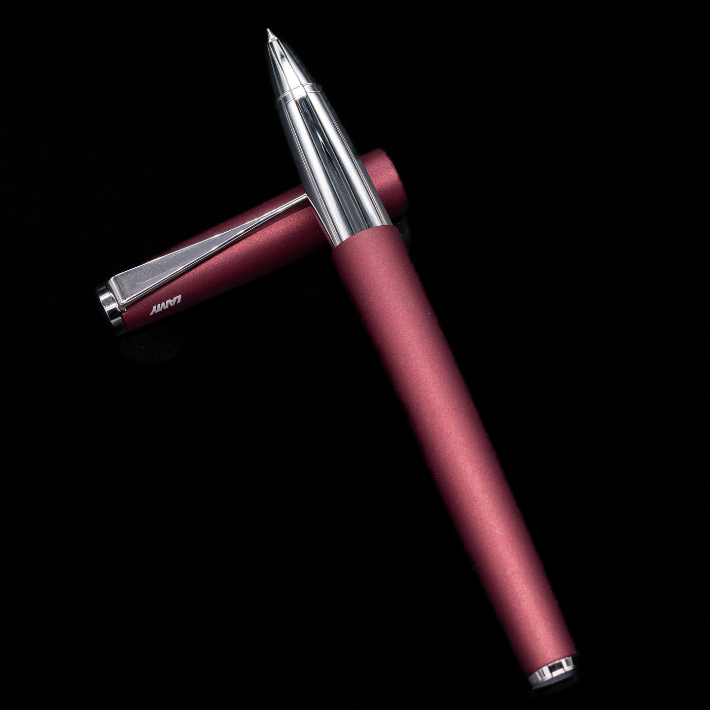 LAMY studio rollerball pen orion laying on top of its cap in a crossed position showing full view of the entire uncapped pen.