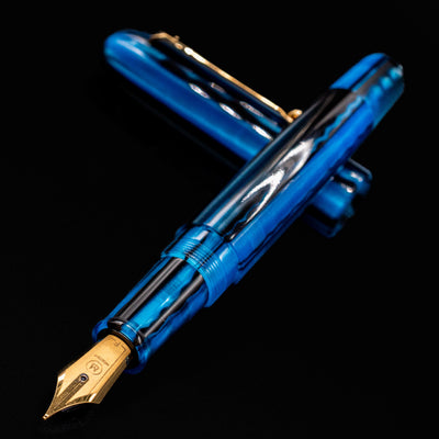 Close-up of Molteni Modelo 71 Blue & Gold Fountain Pen showing gold nib and glossy blue acrylic barrel.