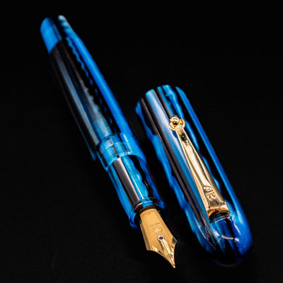 Molteni Modelo 71 Blue & Gold Fountain Pen open with cap placed beside barrel on black backdrop.