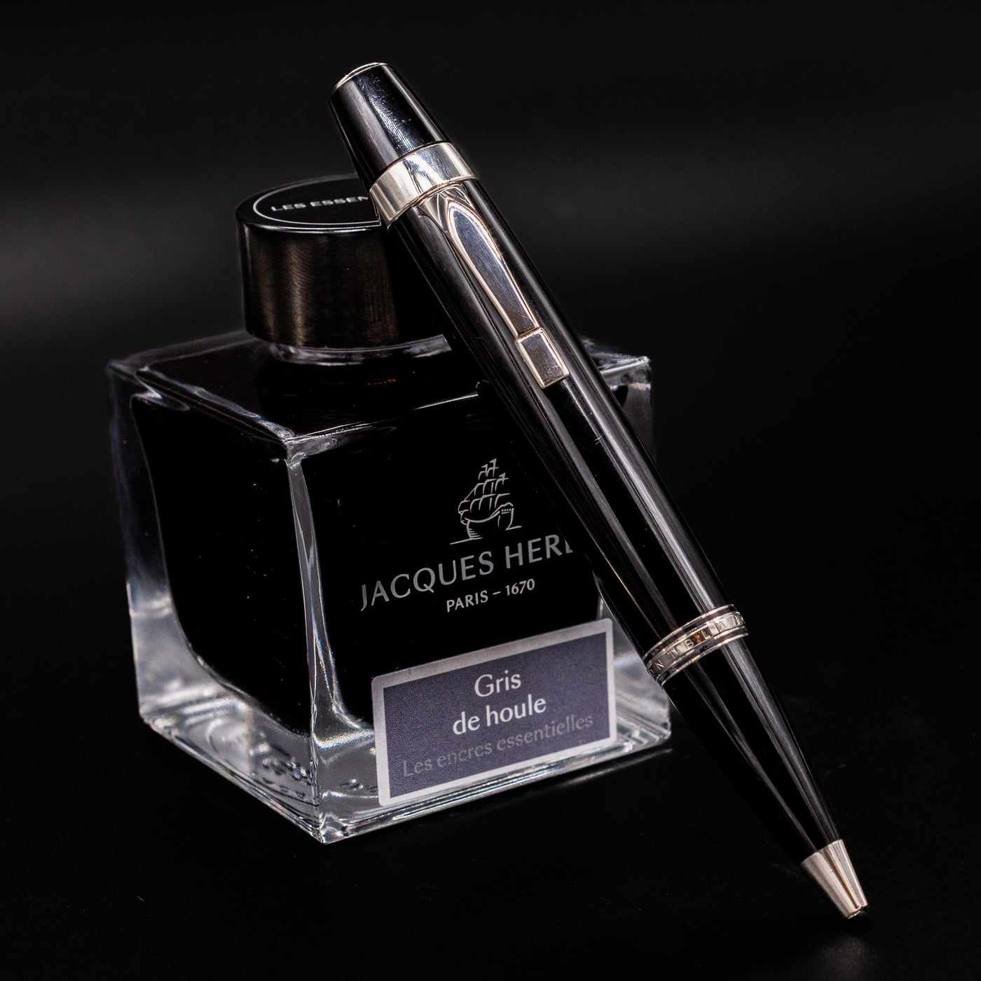 Montblanc Boheme No Stone Ballpoint Pen resting on Jacques Herbin ink bottle, showing platinum trim and sleek black resin