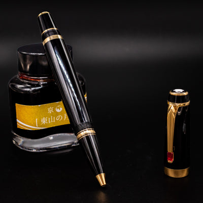 Montblanc Boheme Rouge Rollerball Pen - Preowned propped against yellow ink bottle with cap standing