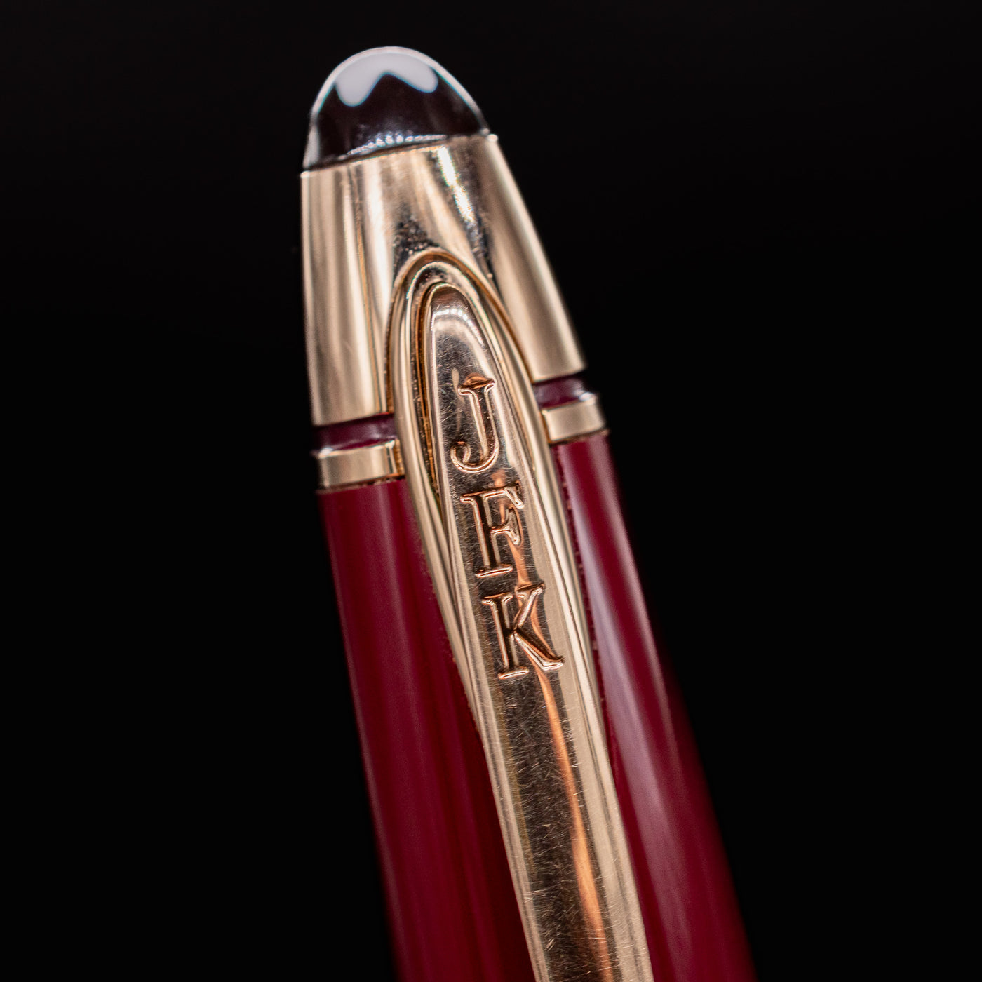 Detail shot of the Montblanc JFK pen clip with engraved "JFK" initials and gold-plated finish.