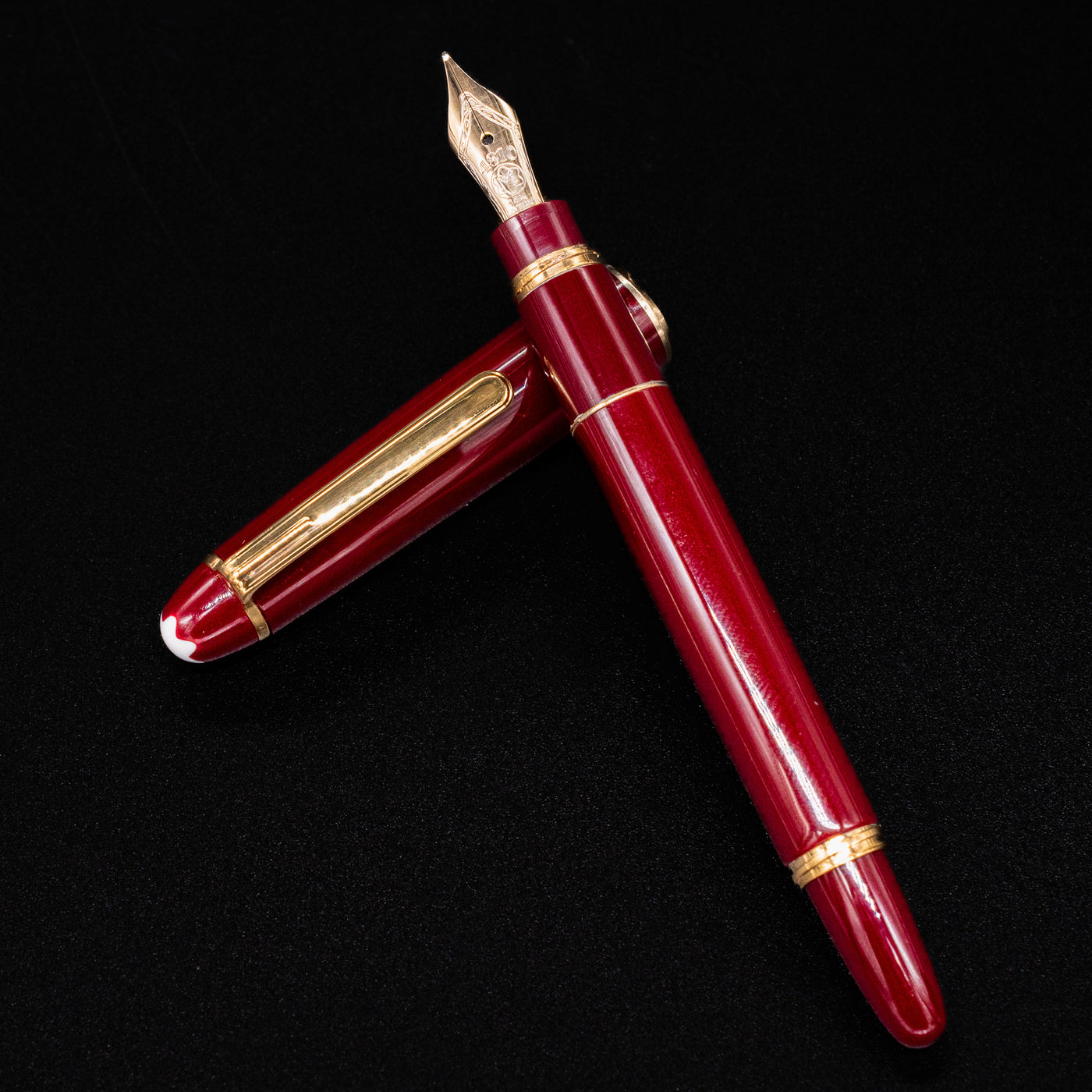 Flatlay view of the Montblanc Meisterstuck 114R Bordeaux & Gold Mozart Fountain Pen with cap off, showcasing the gold nib – Preowned