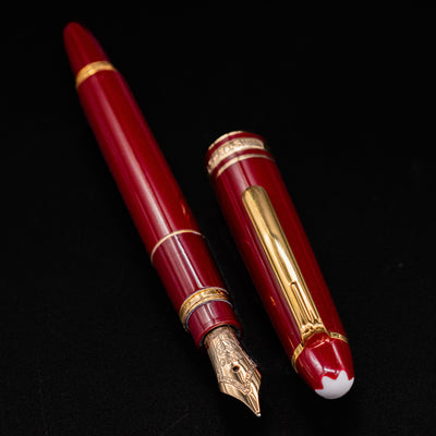 Uncapped Montblanc Meisterstuck 114R Bordeaux & Gold Mozart Fountain Pen – Preowned, showing the gold nib and cap placed beside it.