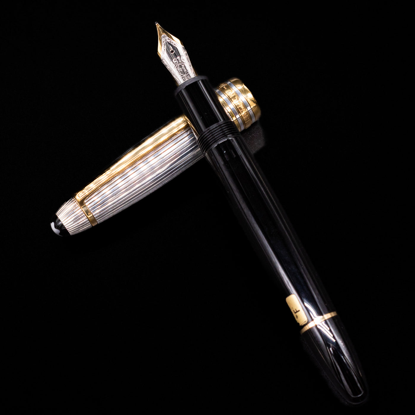 Flatlay of Montblanc Meisterstück 146DS Solitaire Doue LeGrand fountain pen uncapped with striped cap placed below the barrel