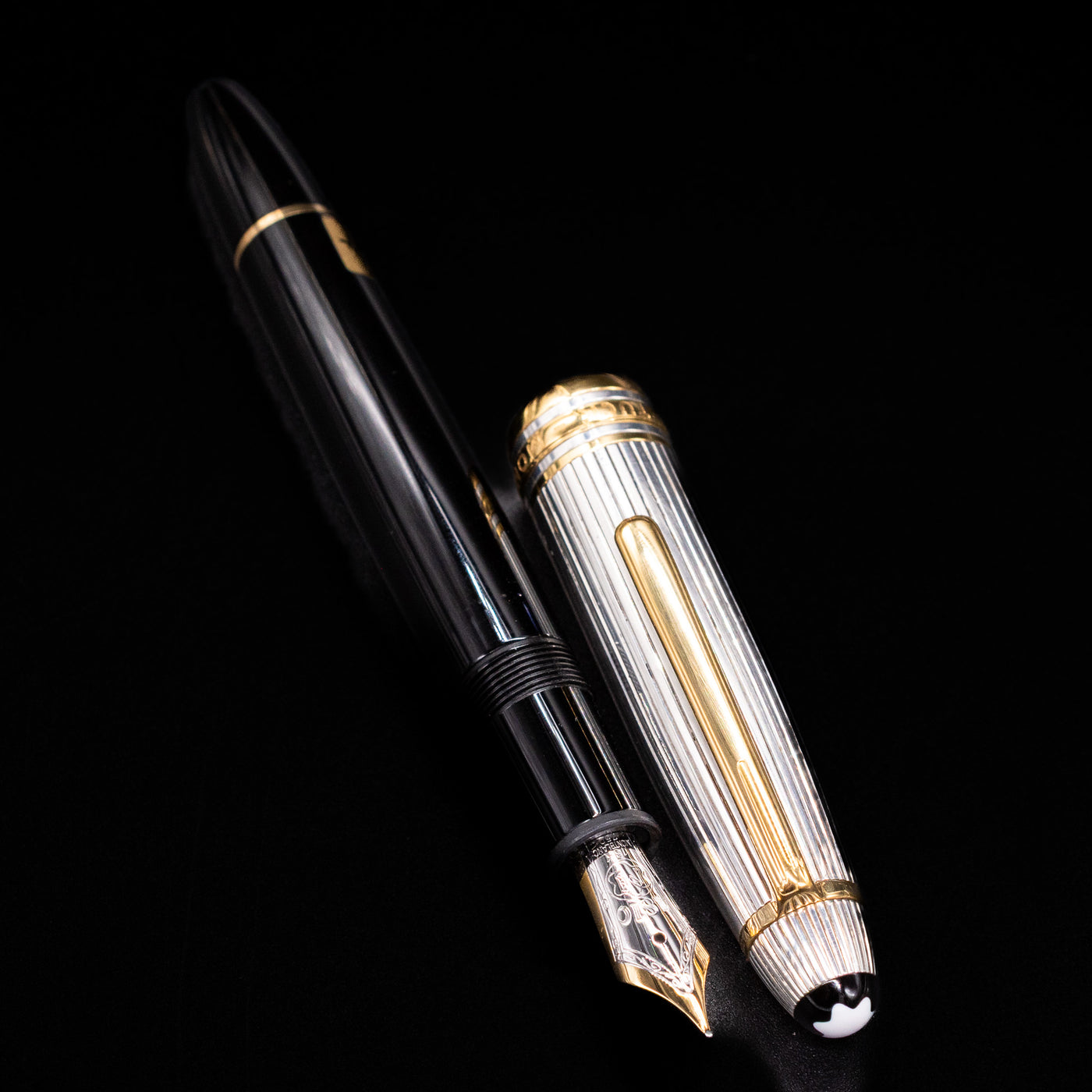Montblanc Meisterstück 146DS Solitaire Doue LeGrand fountain pen with nib exposed beside the striped silver cap with gold trim