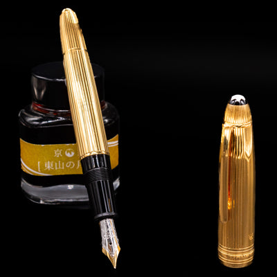 Capped Montblanc Meisterstück 146V Vermeil Pinstripe LeGrand Fountain Pen resting on yellow label ink bottle