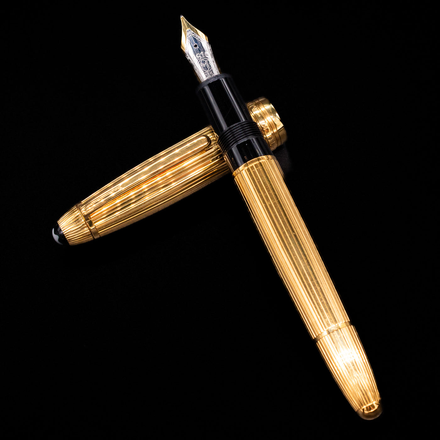 Flat lay of open Montblanc Meisterstück 146V Vermeil Pinstripe LeGrand Fountain Pen with cap beside