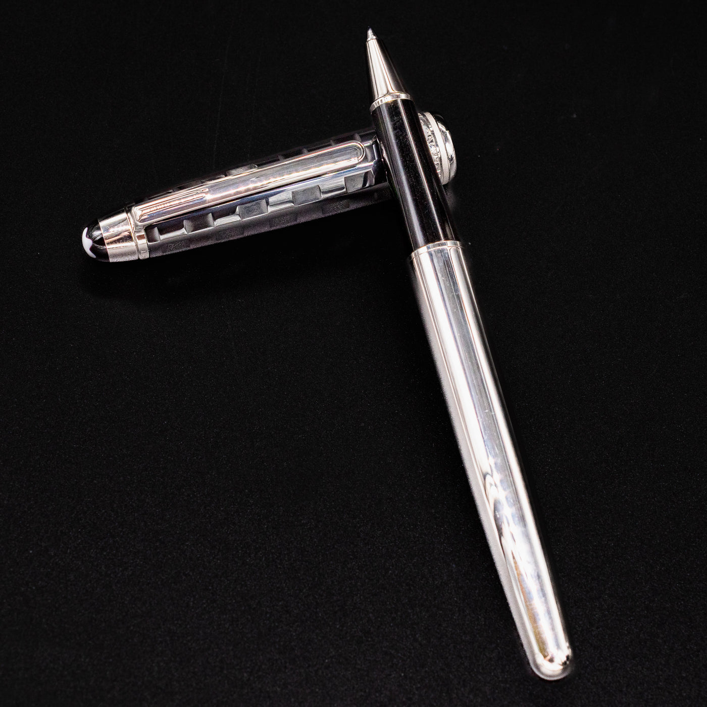 Uncapped Montblanc Meisterstuck 163 Solitaire Ceramics Prisma Rollerball Pen with cap beside it on black background