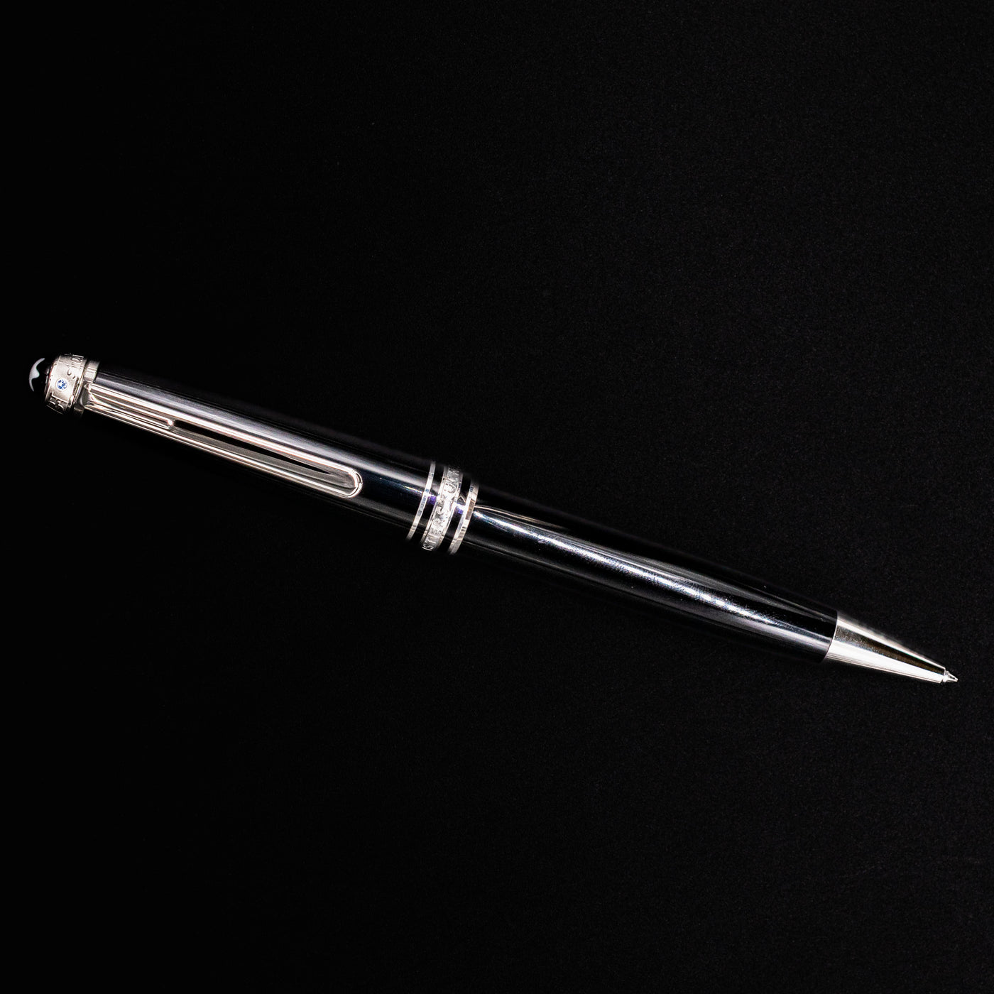 Full view of the Montblanc Meisterstück 164 UNICEF Black & Platinum Ballpoint Pen on black background – preowned