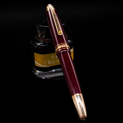 Capped Montblanc Meisterstück Le Petit Prince Planet LeGrand Fountain Pen resting on ink bottle