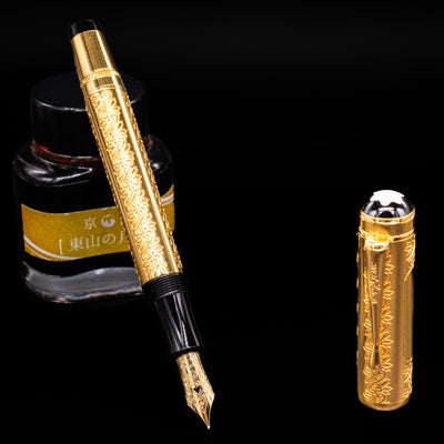 Montblanc Patron of Art Louis XIV 4810 Fountain Pen open with ink bottle in background on black surface