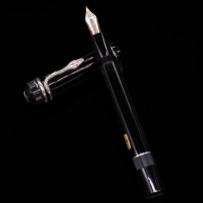 Side view of the pen with the cap unposted, highlighting the serpent clip and pen barrel.