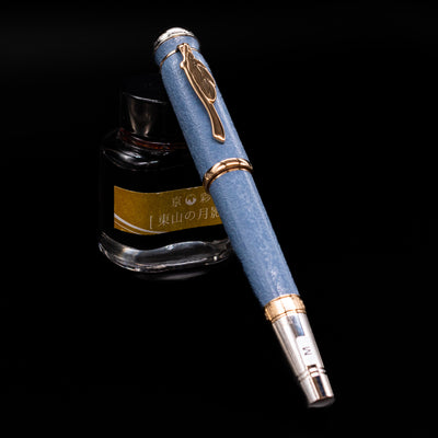 Flatlay of the Montblanc Writer's Edition Johann Wolfgang von Goethe Fountain Pen in capped position, showcasing blue resin.