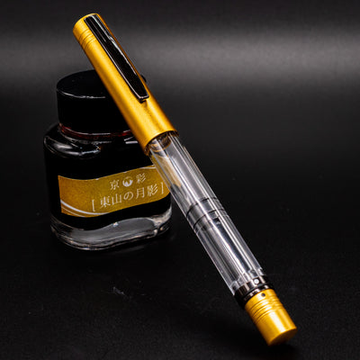 Monteverde MP1 Honey Yellow Fountain Pen capped and resting on a yellow-labeled ink bottle.