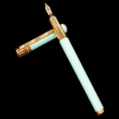 Flatlay of Must de Cartier Trinity Tiffany Blue Fountain Pen uncapped, highlighting elegant slim profile
