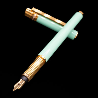 Open Must de Cartier Tiffany Blue Fountain Pen showing gold nib and fluted grip section with cap in background