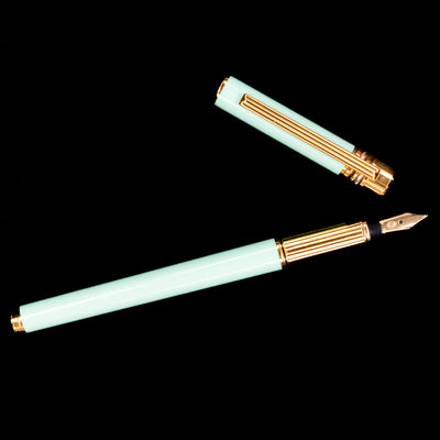 Top-down view of Must de Cartier Trinity Tiffany Blue Fountain Pen uncapped with nib facing right