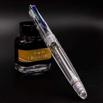 Nahvalur Fathom Pride 2025 clear fountain pen open beside yellow-labeled ink bottle