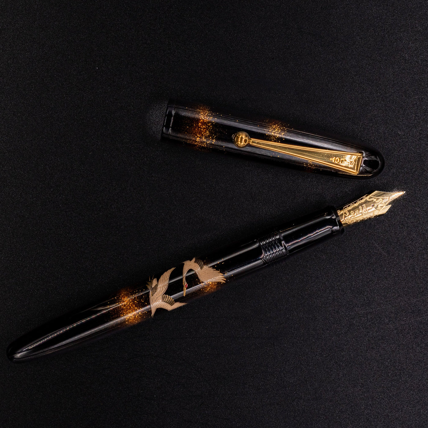 Overhead shot of Namiki Yukari Double Crane fountain pen with gold trim.