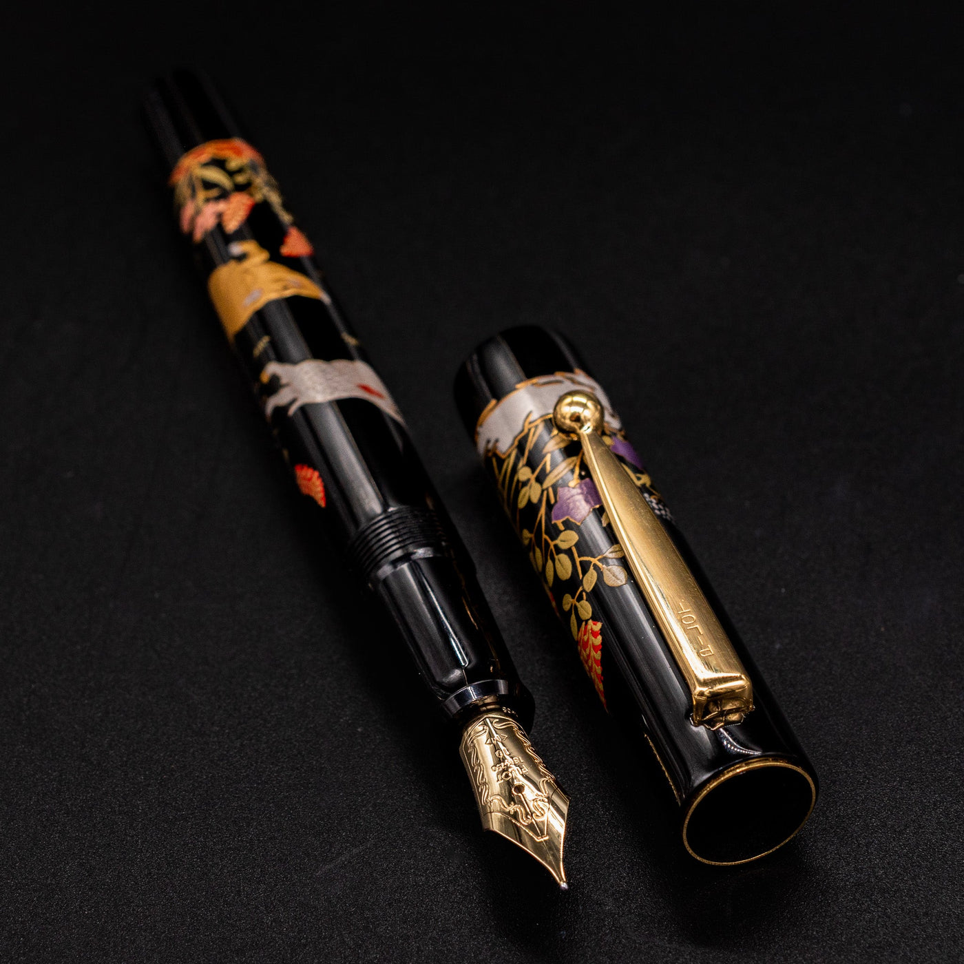 Namiki Yukari Zodiac Boar pen uncapped and angled overhead - black lacquer and gold trim