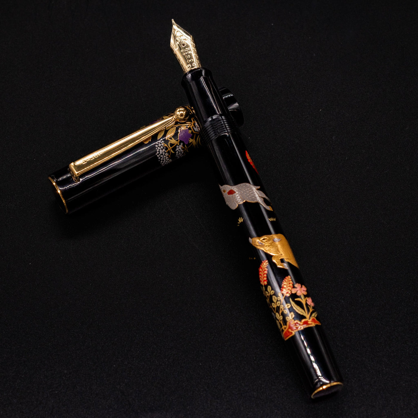 Namiki Yukari Zodiac Boar fountain pen body resting on cap - intricate maki-e artwork