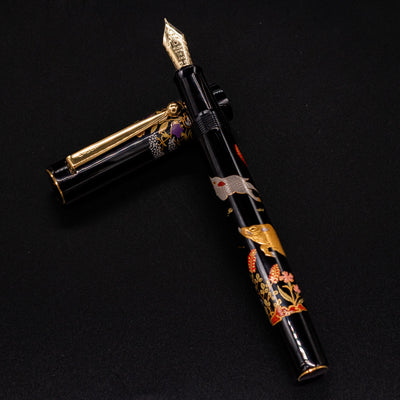 Namiki Yukari Zodiac Boar fountain pen body resting on cap - intricate maki-e artwork