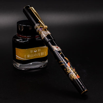 Namiki Yukari Zodiac Boar pen capped restin on ink bottle - handcrafted Japanese fountain pen