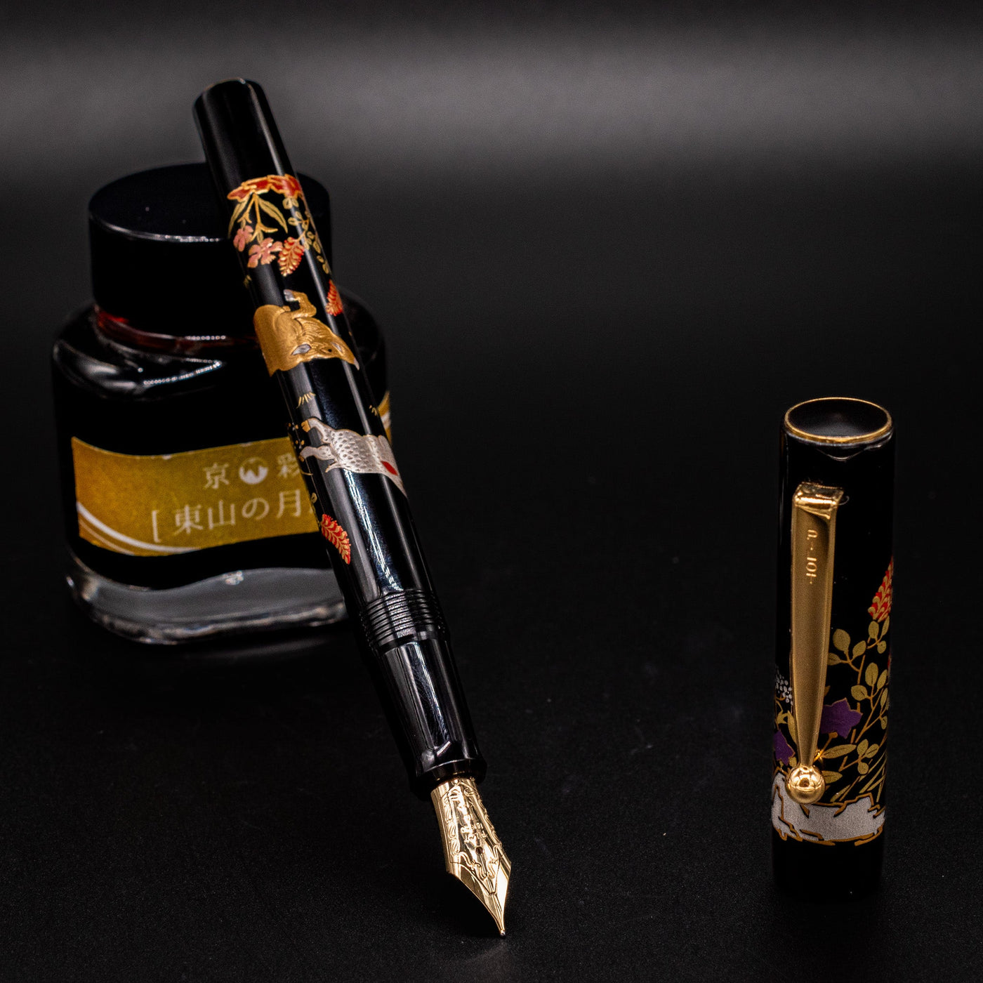 Namiki Yukari Zodiac Boar fountain pen uncapped restin on ink bottle - luxury Japanese Maki-e pen