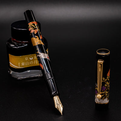 Namiki Yukari Zodiac Boar fountain pen uncapped restin on ink bottle - luxury Japanese Maki-e pen
