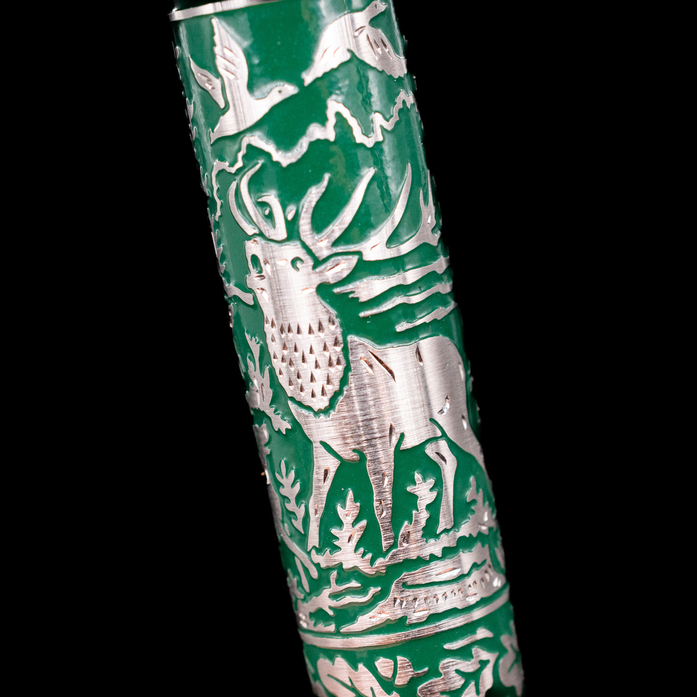 Detailed image of engraved deer and forest trees on the barrel of the Pelikan M915 Hunting Fountain Pen