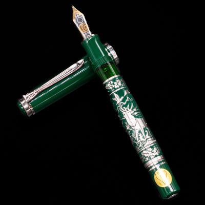 Close-up of the capped Pelikan M915 Hunting fountain pen, highlighting the green resin and engraved metal barrel.