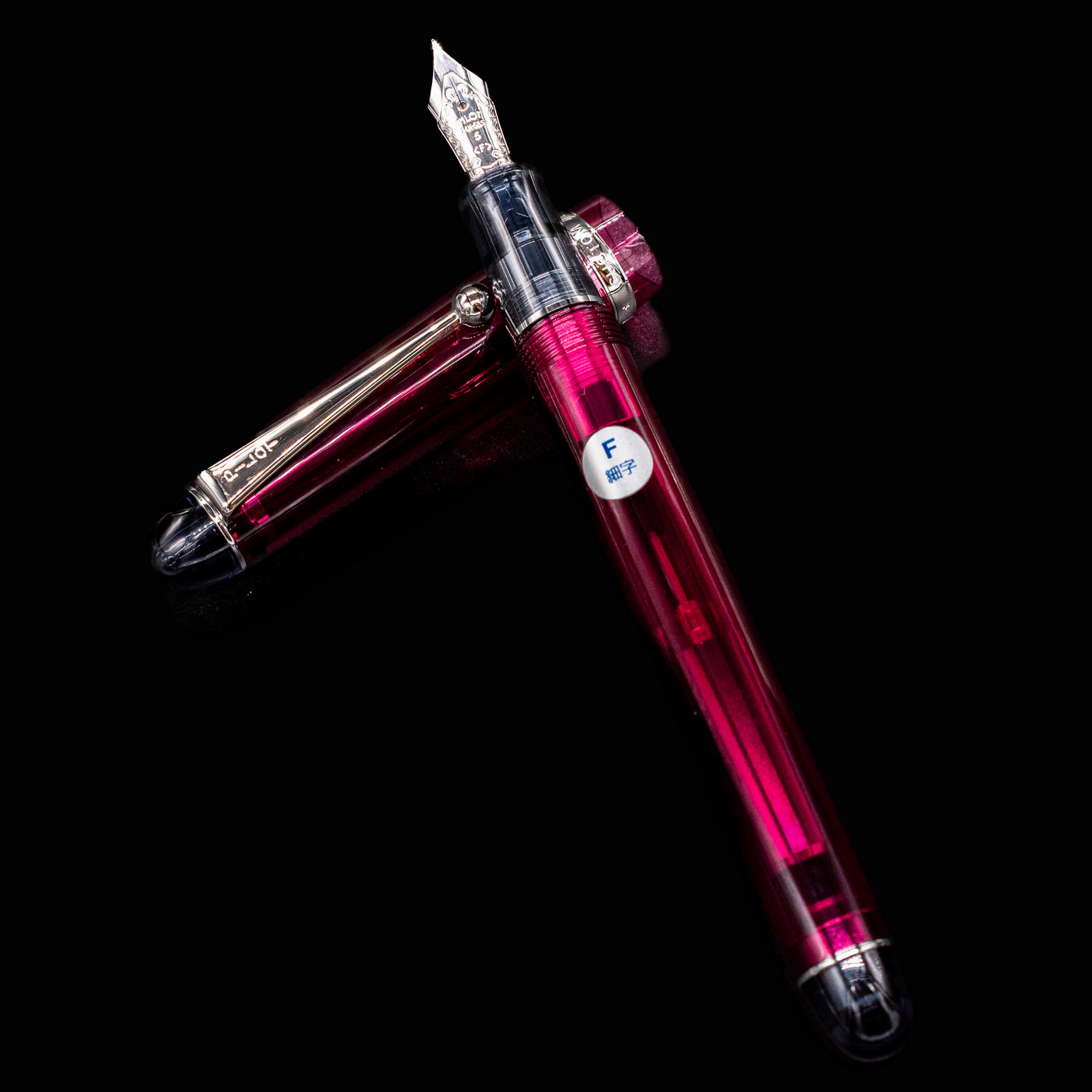 Pilot Custom 74 Merlot fountain pen with cap off and placed beside the pen, highlighting transparent red body