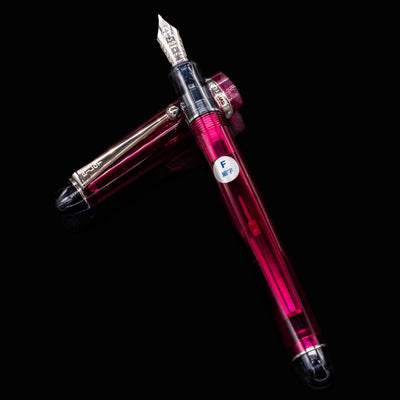Pilot Custom 74 Merlot fountain pen with cap off and placed beside the pen, highlighting transparent red body