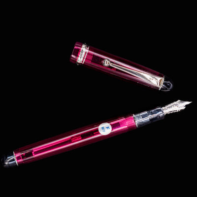 Pilot Custom 74 Merlot fountain pen uncapped with silver nib pointing upward, cap laid flat beside it