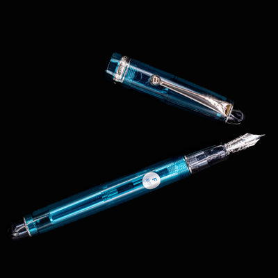 Flat lay of Pilot Custom 74 Teal Fountain Pen with separated cap and exposed nib