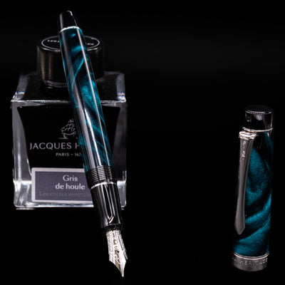 Pilot Custom Heritage SE Green Marble Fountain Pen with nib exposed, resting on Jacques Herbin Gris de Houle ink bottle
