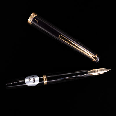 Horizontal layout of uncapped Pilot E95S Fountain Pen in Black with cap above the pen