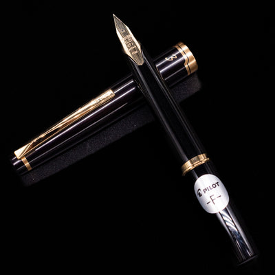 Flat lay of open Pilot E95S Fountain Pen in Black with cap placed beside it