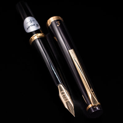 Pilot E95S Fountain Pen in Black displayed next to its cap with gold clip and engraved detailing