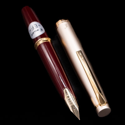 Close-up of Pilot E95S Fountain Pen Burgundy and Ivory showing gold nib and gold-trimmed cap